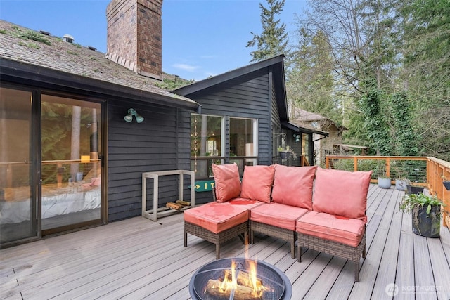 wooden terrace featuring an outdoor living space with a fire pit