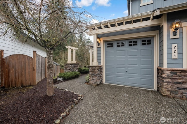 garage with aphalt driveway and fence