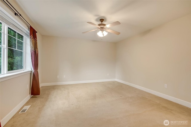 empty room with visible vents, light colored carpet, and baseboards