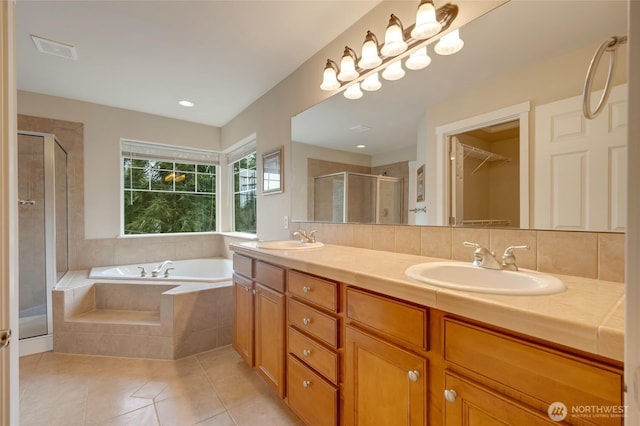 bathroom with a sink, a garden tub, a shower stall, and tile patterned flooring