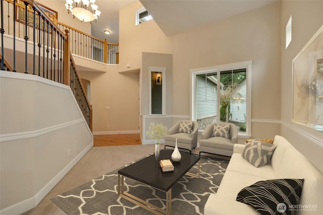 living area featuring a wealth of natural light, a notable chandelier, stairway, and a high ceiling