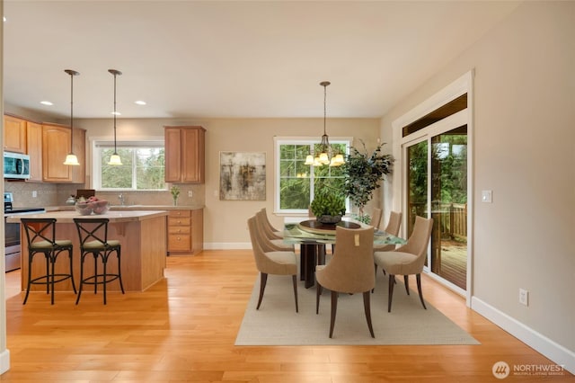 dining room with recessed lighting, a notable chandelier, light wood-style floors, and baseboards