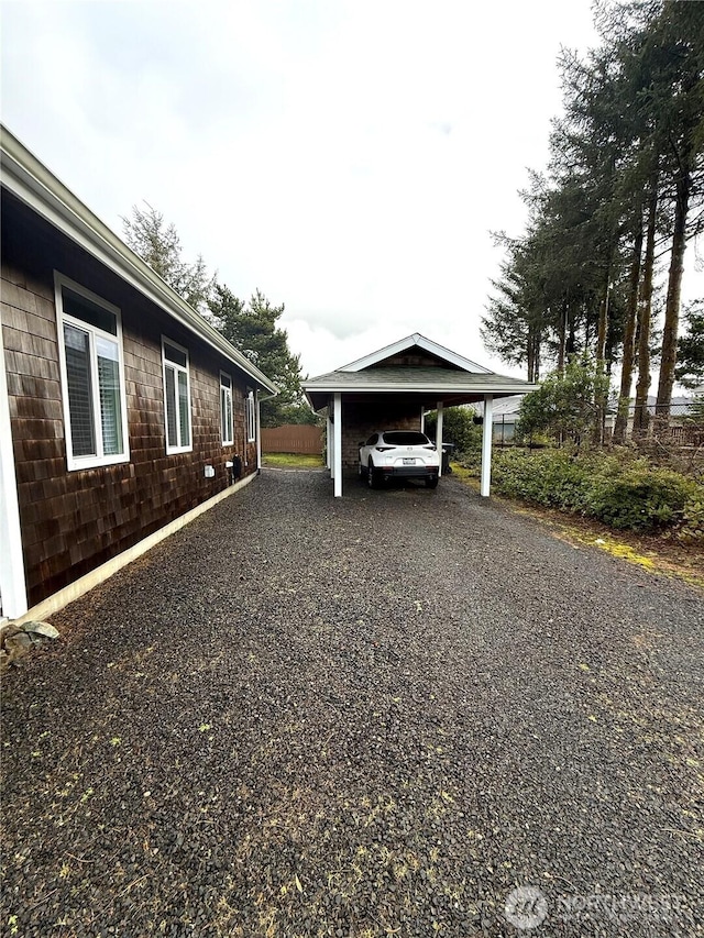 view of parking with a carport and gravel driveway