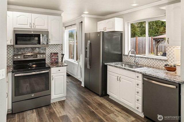 kitchen featuring stone counters, dark wood-style floors, appliances with stainless steel finishes, white cabinetry, and a sink