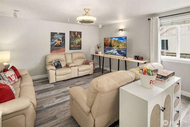 living area with baseboards and wood finished floors