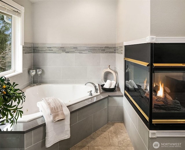 full bathroom with a multi sided fireplace and a bath