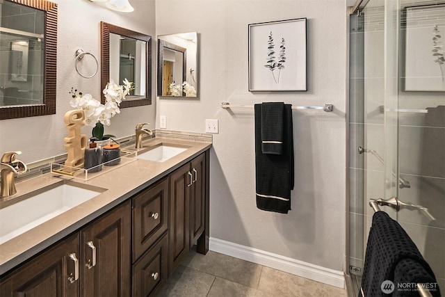 full bath featuring a sink, a shower stall, and tile patterned floors