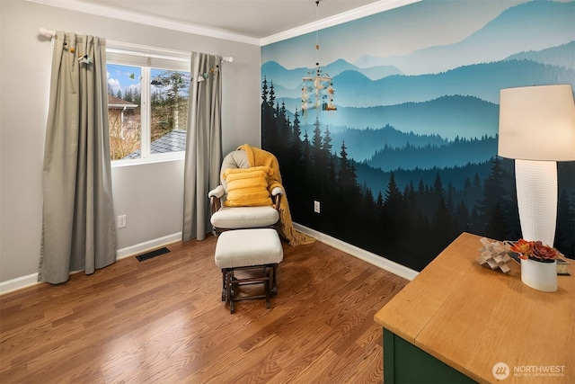 living area with visible vents, crown molding, baseboards, and wood finished floors