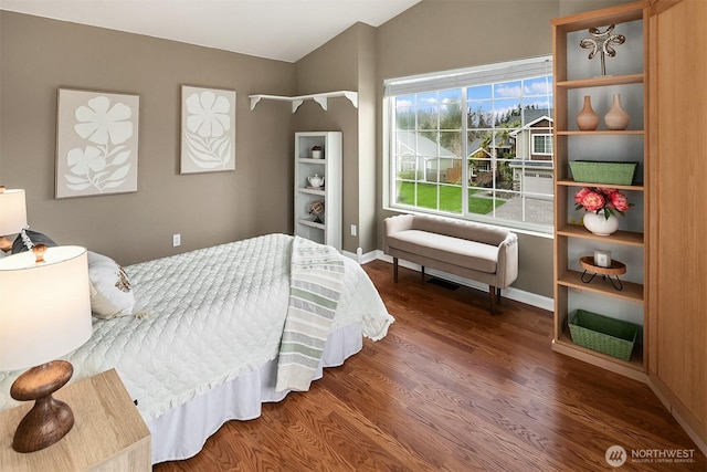 bedroom with lofted ceiling, wood finished floors, and baseboards