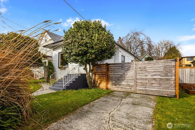 view of front facade featuring a front yard and fence