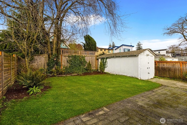 view of yard featuring a storage unit, an outdoor structure, and a fenced backyard