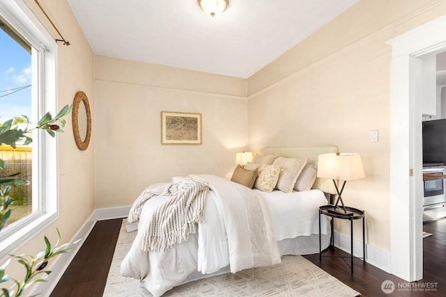 bedroom featuring dark wood-type flooring, multiple windows, and baseboards