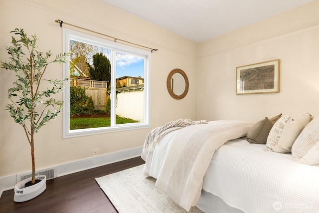 bedroom with visible vents, dark wood finished floors, and baseboards