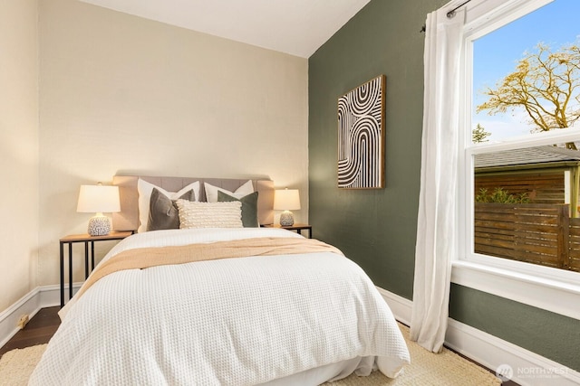 bedroom with baseboards and wood finished floors