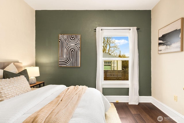 bedroom with dark wood-style floors and baseboards