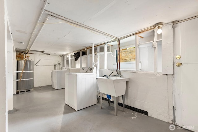 basement with strapped water heater, separate washer and dryer, and a sink