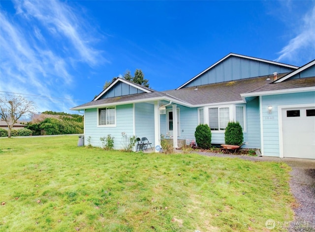 rear view of house with a garage, board and batten siding, and a lawn