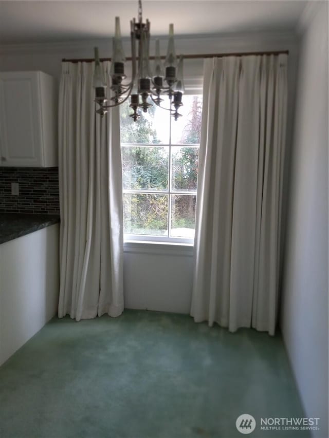 unfurnished dining area with light carpet, an inviting chandelier, and crown molding