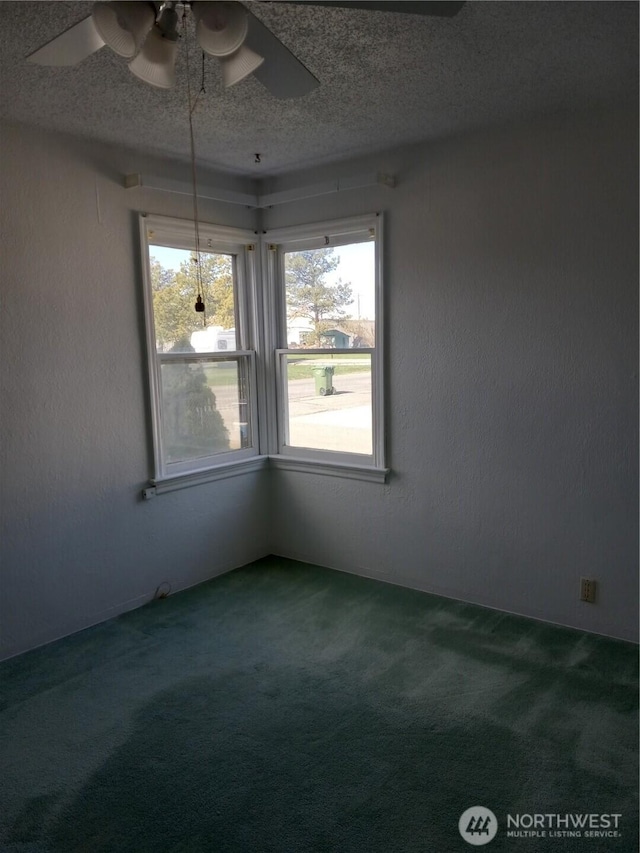 empty room featuring a textured ceiling, a ceiling fan, and carpet flooring