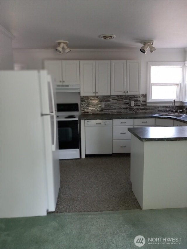 kitchen featuring dark countertops, white appliances, white cabinetry, and a sink