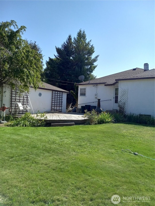 back of house with a lawn and a deck