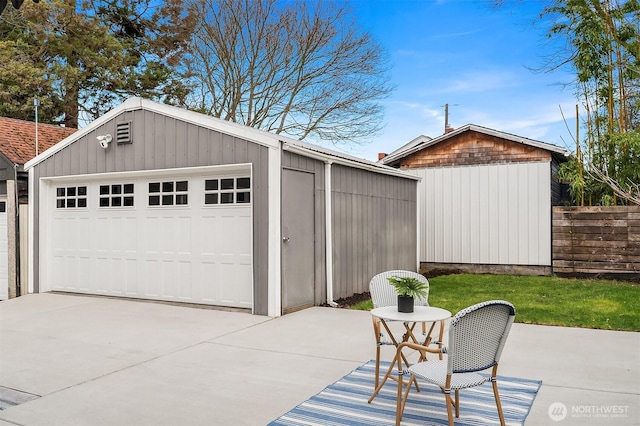 detached garage featuring fence