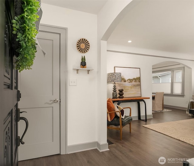 foyer entrance featuring dark wood finished floors, recessed lighting, baseboards, and arched walkways