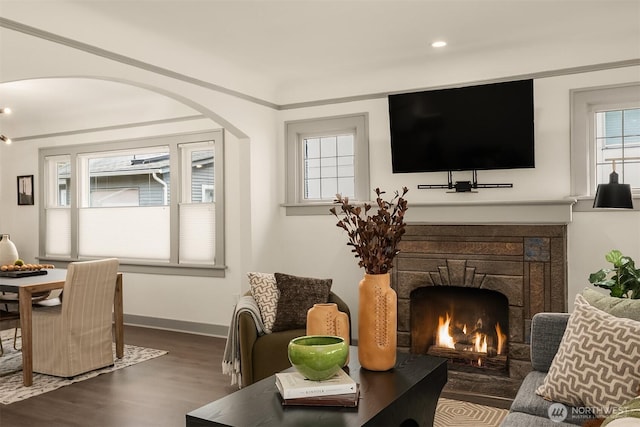 living room featuring dark wood-type flooring, recessed lighting, a fireplace, and baseboards