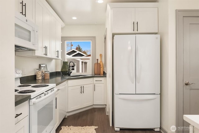 kitchen with white appliances, white cabinetry, and a sink