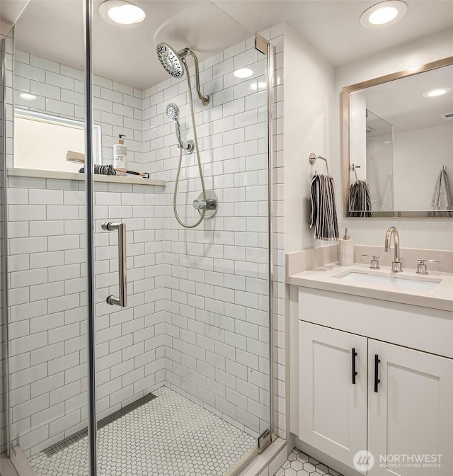 bathroom with recessed lighting, vanity, and a shower stall