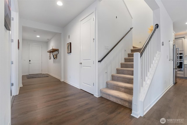 interior space with recessed lighting, dark wood finished floors, stairway, and baseboards