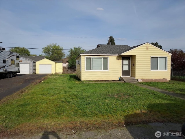 view of front of property featuring a front yard, a garage, driveway, entry steps, and fence