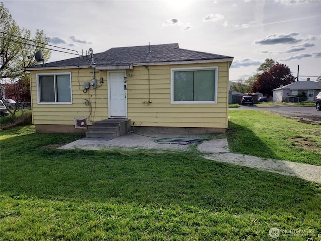 rear view of house featuring a yard
