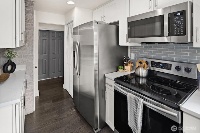 kitchen featuring white cabinets, light countertops, appliances with stainless steel finishes, backsplash, and dark wood finished floors