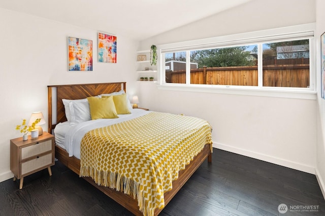 bedroom with lofted ceiling, dark wood finished floors, and baseboards