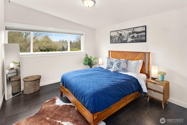 bedroom featuring lofted ceiling, dark wood finished floors, and baseboards