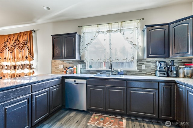 kitchen with dark wood finished floors, light countertops, backsplash, a sink, and dishwasher