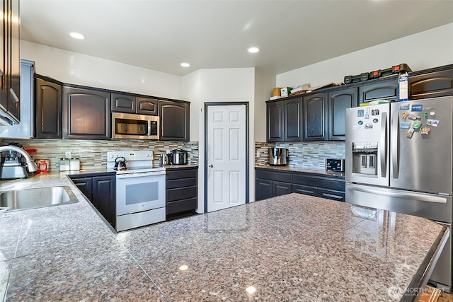 kitchen featuring stainless steel appliances, recessed lighting, a sink, and decorative backsplash