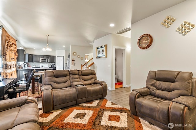 living room featuring recessed lighting, visible vents, baseboards, light wood-style floors, and an inviting chandelier