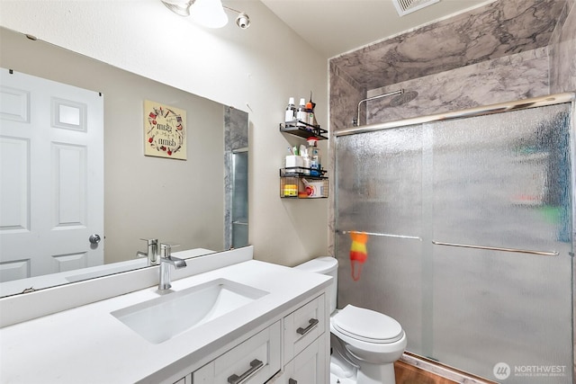 full bath featuring toilet, a stall shower, and vanity