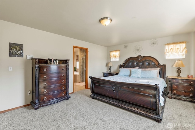 bedroom with baseboards, ensuite bath, and light colored carpet