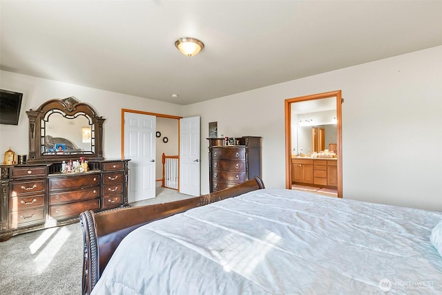 bedroom with light colored carpet and ensuite bathroom