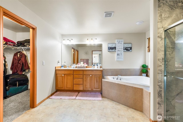 full bath with a shower stall, visible vents, a walk in closet, and a sink