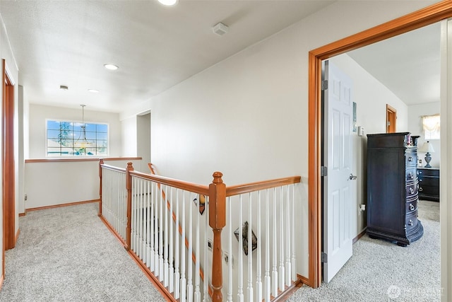 corridor featuring light carpet, an upstairs landing, baseboards, and recessed lighting