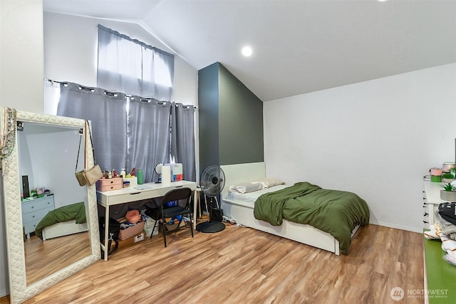 bedroom with vaulted ceiling and wood finished floors