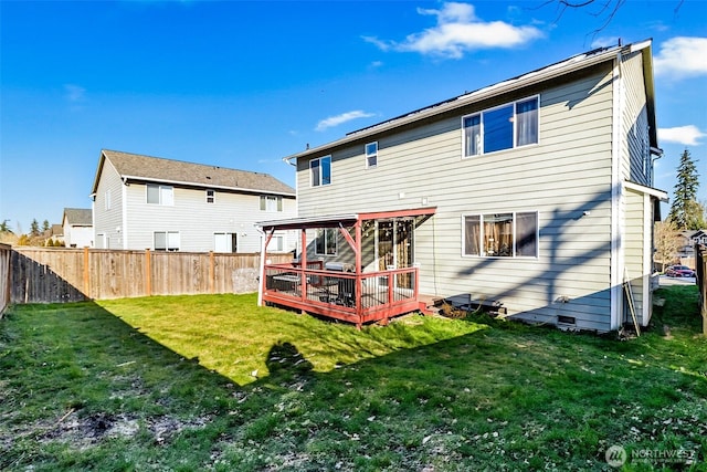 rear view of house with a yard, a deck, and fence