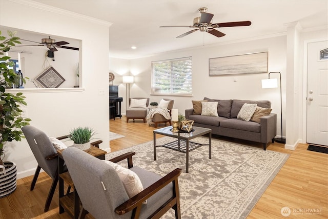 living area with ceiling fan, baseboards, crown molding, and wood finished floors