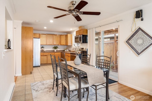 dining area featuring light tile patterned floors, ornamental molding, and baseboards