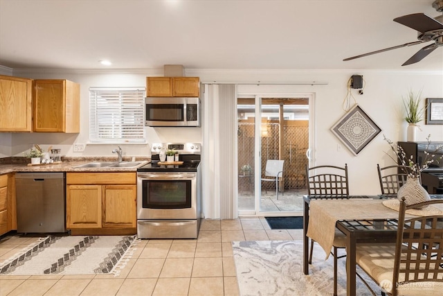 kitchen featuring stainless steel appliances, plenty of natural light, a sink, and light tile patterned floors