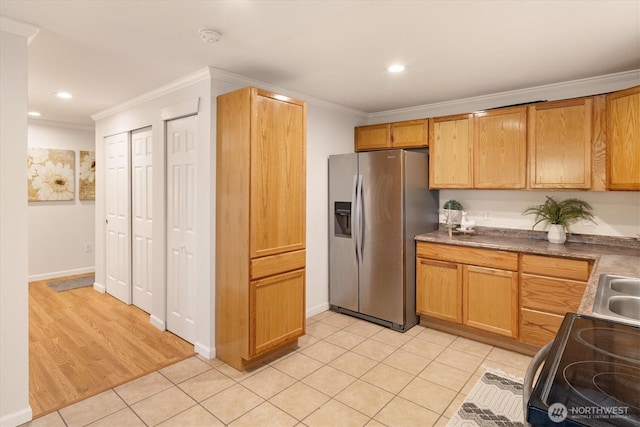 kitchen featuring light tile patterned floors, dark countertops, appliances with stainless steel finishes, ornamental molding, and recessed lighting